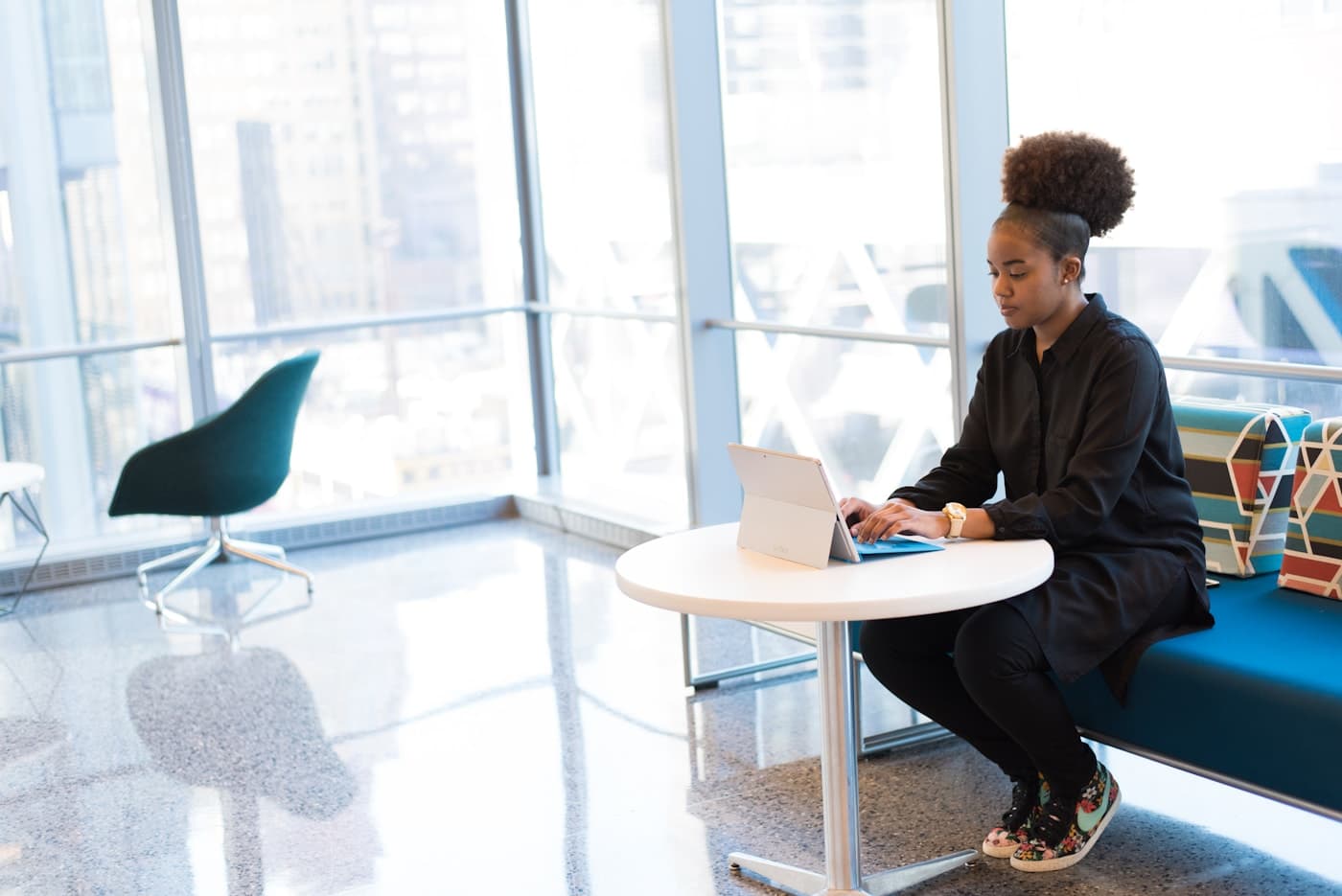 African founder working alone on a laptop in a colourful lounge, still unclear what to ship